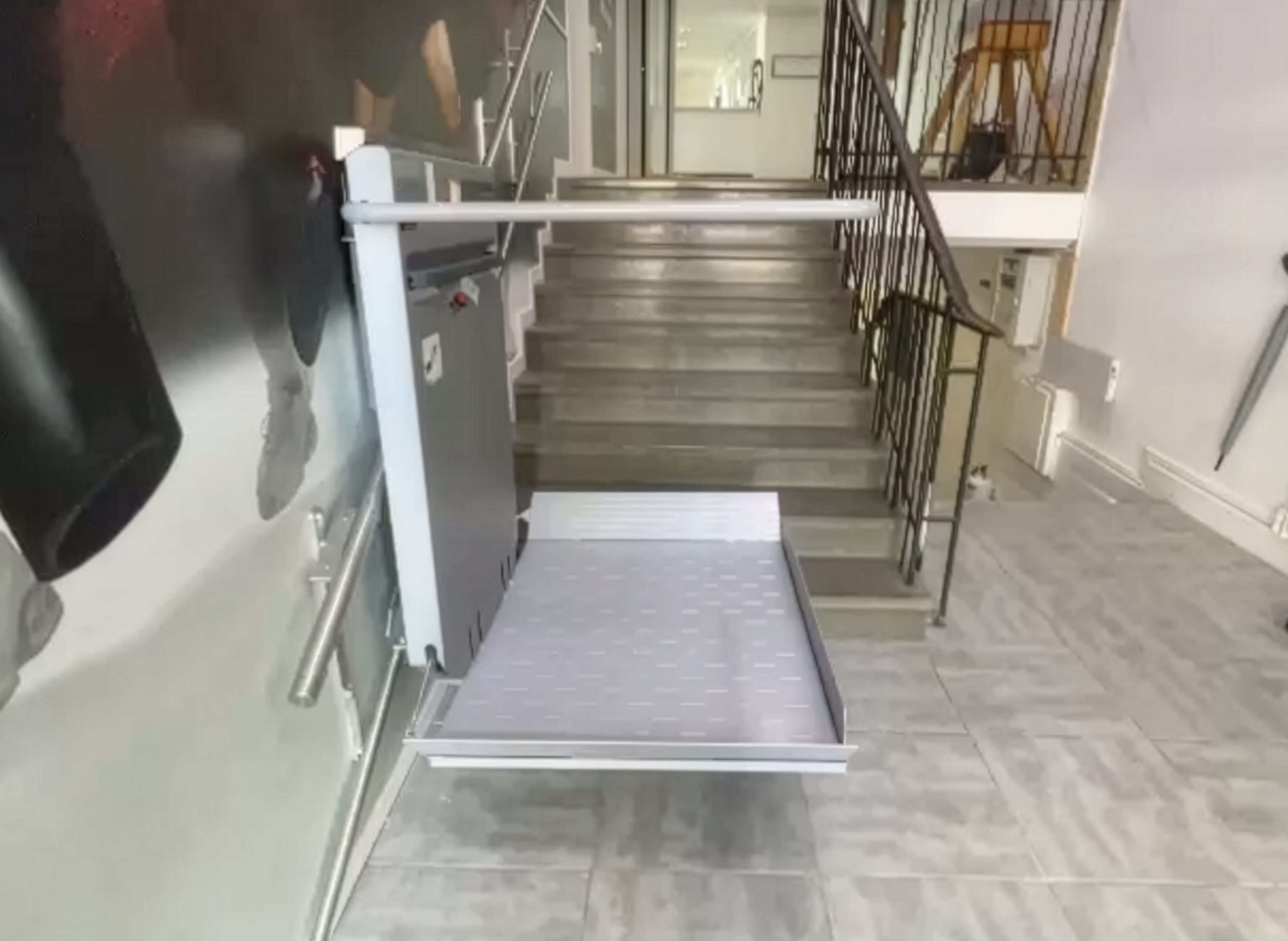 Modern folding stair lift at the base of the main staircase