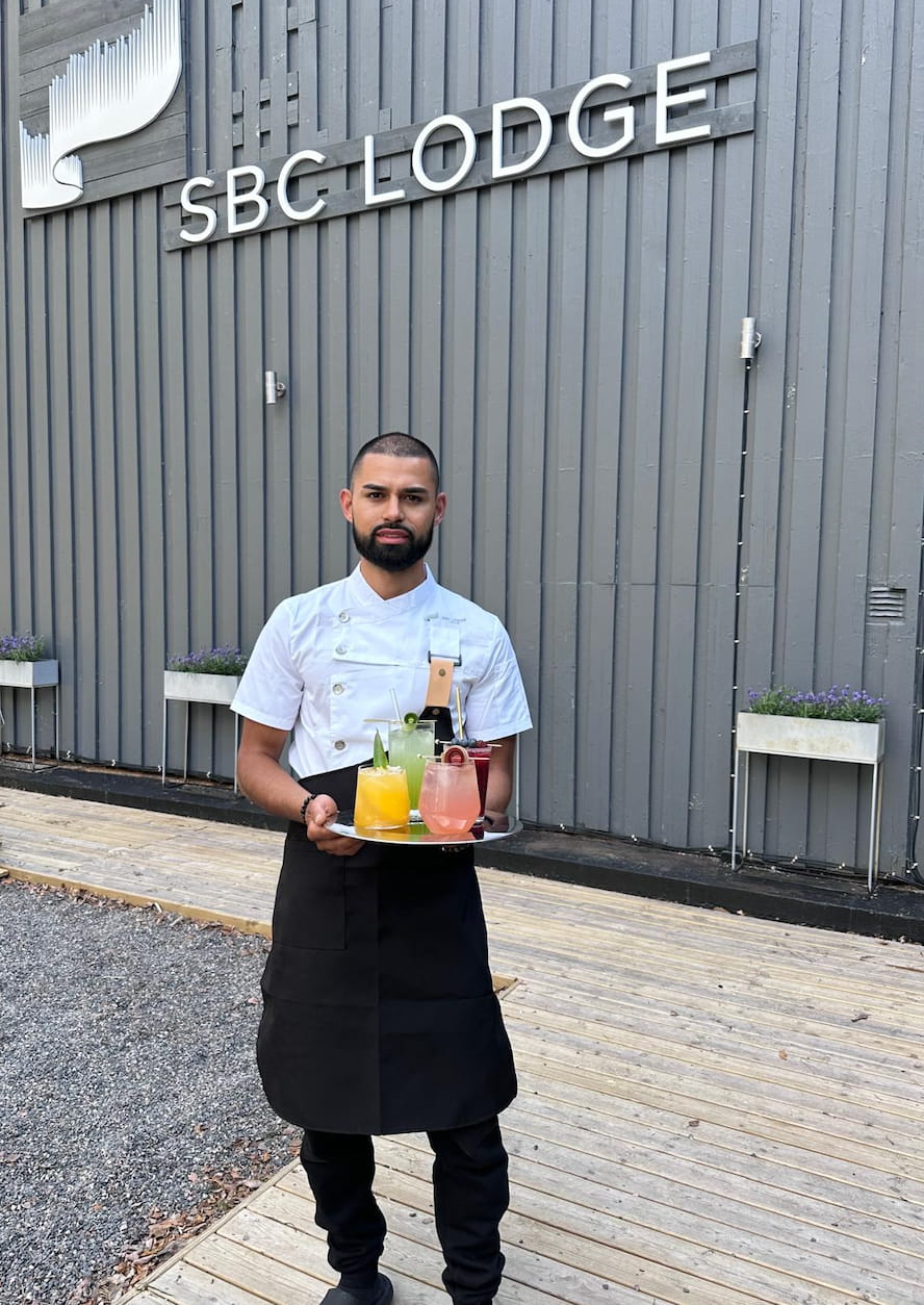 SBC Lodge barman in uniform with cocktails