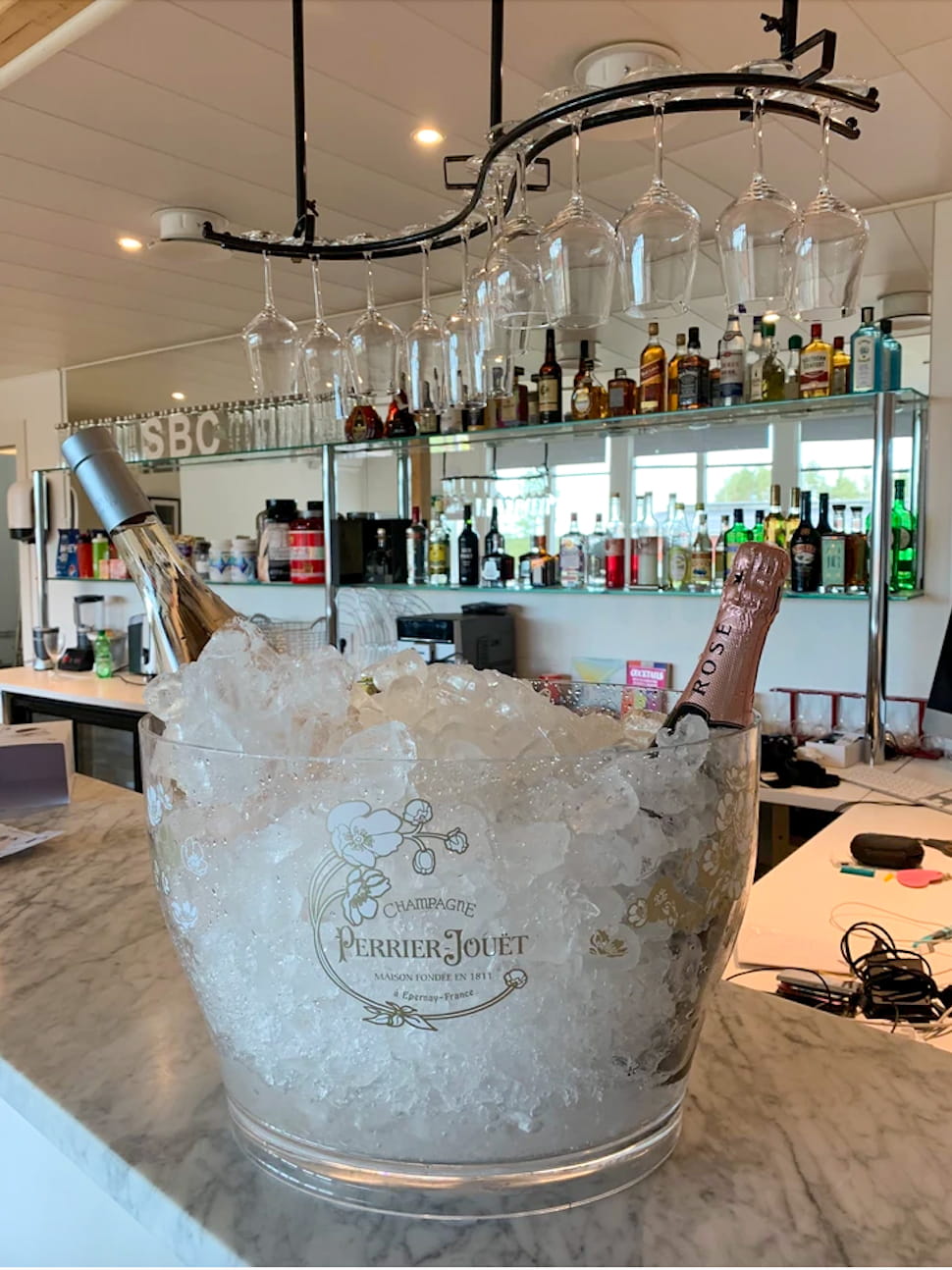 SBC Lodge marble bar with Perrier-Jouët and spirits wall