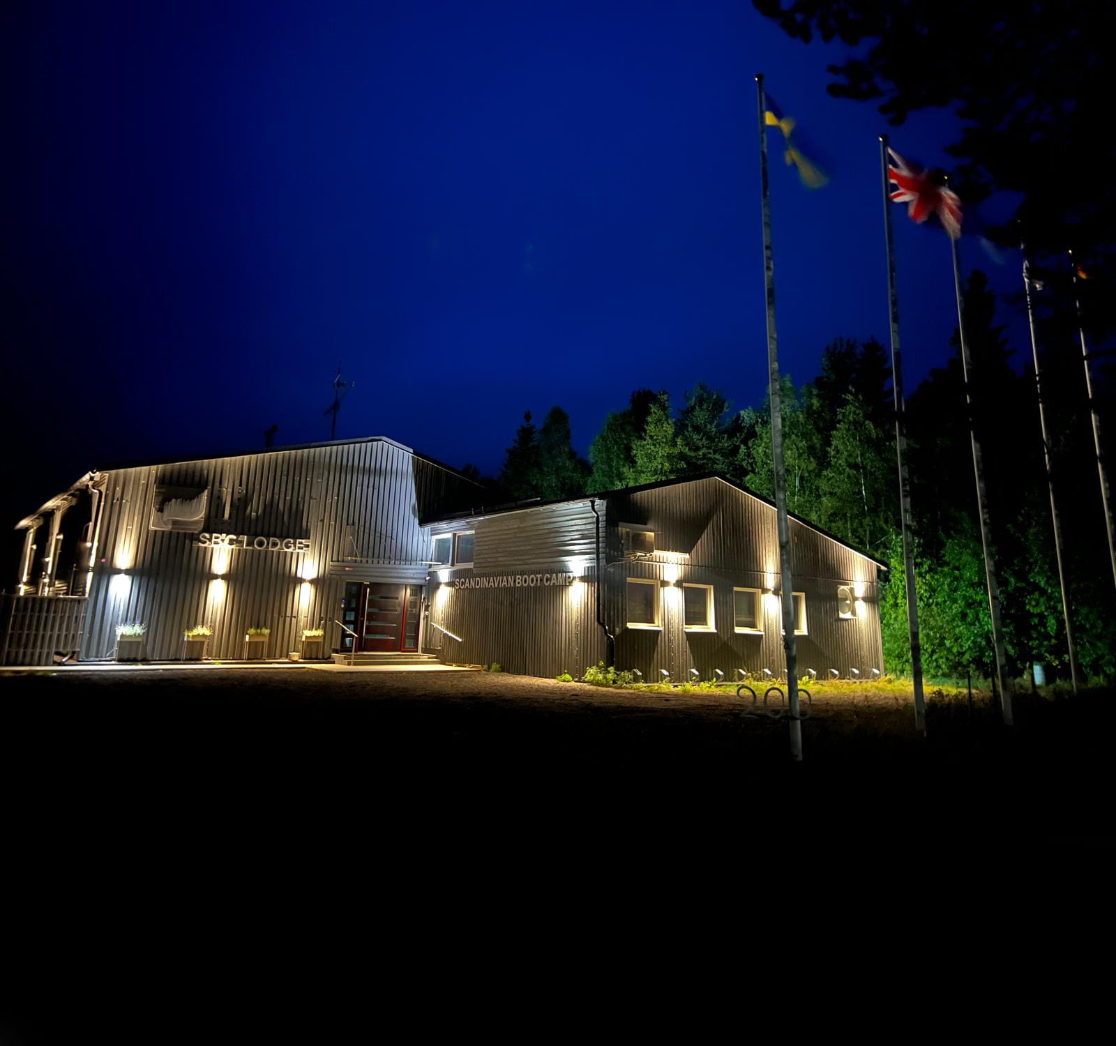 SBC Lodge — night exterior with flags