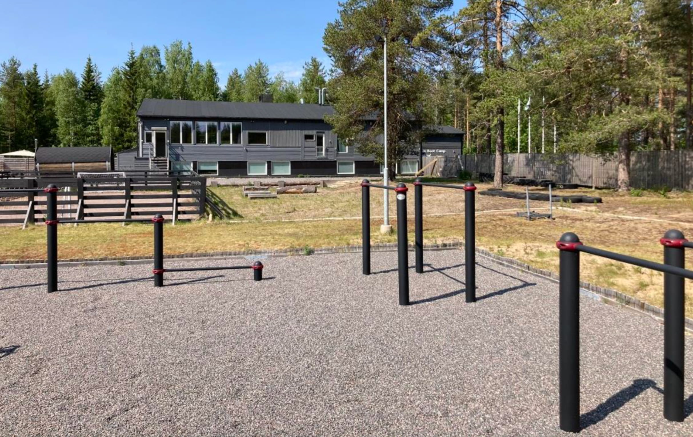 The grounds at SBC Lodge with outdoor calisthenics infrastructure and the lodge in the background